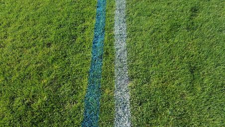 Aufsicht auf Rasen mit zwei parallelen Strichen. Markierungen für das Fussballfeld.