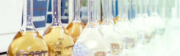 Forschung_Entwicklung_Labor Messkolben mit Flüssigkeit, aufgereiht im Labor.