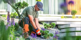 [Translate to Français (CH):] Le jardinier s'occupe du chemin pavé et des plantes.